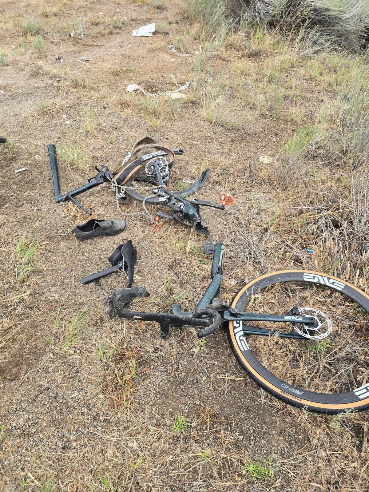 Shattered remains of a carbon road bike on the roadside after the collision