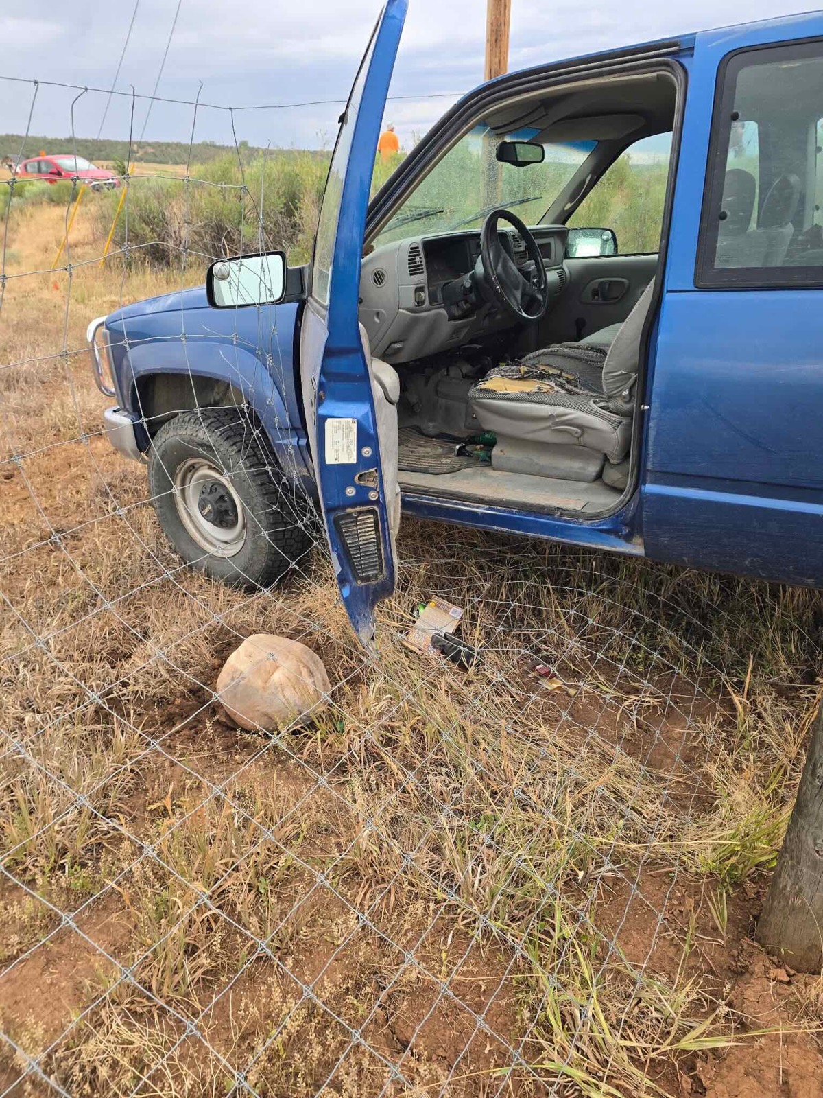 Blue pickup truck that left the road and crashed through a fence after the incident